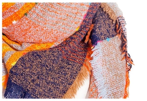 Detaillierte Makroansicht eines dicken bunten Strickschals mit Fransen und weicher Textur