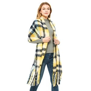 Oversized yellow and blue plaid scarf with thick fringe tassels on a studio model