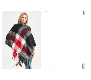 Détail du poncho à carreaux rouges et noirs avec franges épaisses et texture tricotée