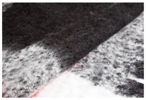 Gros plan sur la texture mohair moelleuse et le motif à carreaux noir et blanc du poncho