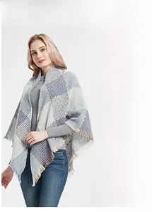 Detail view of women's plaid poncho with soft fringe tassels and hairy texture fabric
