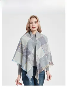 Detail of light blue and grey checkered knit shawl with colorful accents and fringe edges