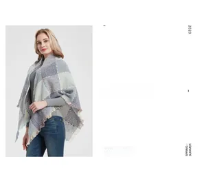 Detail of grey plaid knit shawl with colorful flecks and soft tassel trim accents