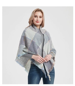 Detail of plaid knit shawl with grey patterns and orange accent fringes texture
