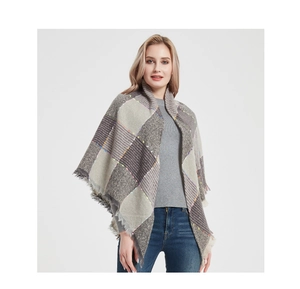 Detail of grey plaid scarf with long tassels and thick knit texture for winter