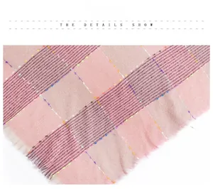 Detail of pink plaid knit scarf showing colorful stitching and soft fringe texture
