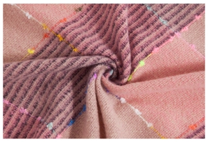 Detailed macro view of soft plaid knit fabric with colorful decorative hand-stitch details