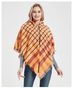 Detail of classic orange plaid thick scarf featuring soft fringe edges and cozy texture