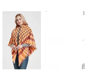 Detailed view of the soft orange plaid knit scarf featuring fringe edges and warm tones