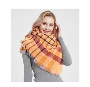 Close-up of thick plaid shawl with orange texture and soft frayed fringe edges