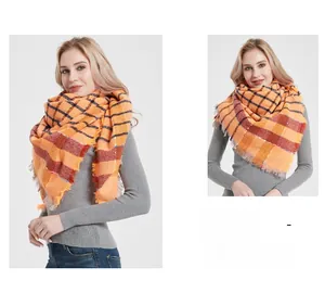 Close-up of orange plaid shawl scarf with tassels and thick textured knit fabric