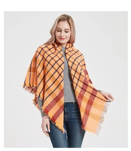 Close-up of orange and brown plaid scarf with soft fringe edges for autumn and winter
