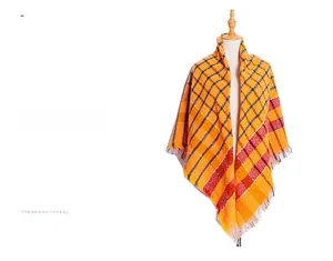 Detail of orange plaid scarf showing textured fringe and soft woven thick fabric