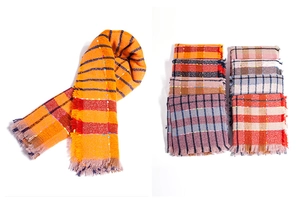 Detail of plaid scarf featuring vibrant orange fringe edges and colorful knit patterns