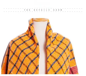 Detail showing the thick orange and black plaid knit texture of the winter shawl scarf