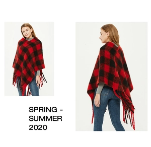 Detail eines rot-schwarzen Karo-Ponchos mit dickem Schlingengarn und Fransenrand