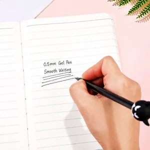 Creative 0.5mm devil cartoon gel pen writing smoothly on a notebook over pink background