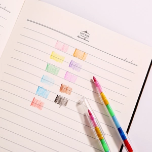 Stackable creative block crayons with multi-color tips next to a minimalist notebook