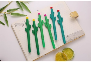 Détail macro de stylos gel en forme de cactus vert avec fleurs colorées sur cahier