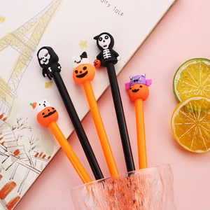 Lot de stylos gel Halloween avec figurines citrouille et crâne sur un bureau rose