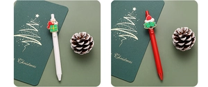Detailed view of Christmas themed gel pens with Santa and snowman resin charms on gift cards