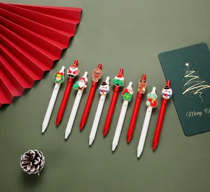 Flat lay of 10 Christmas gel pens with festive silicone charms like Santa and snowman