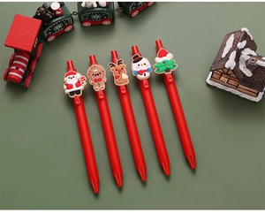 Detail of red Christmas gel pens featuring cartoon Santa, reindeer, and snowman charms