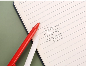 Detail of red and white retractable gel pens showing smooth black ink writing on paper