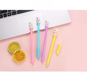 Close-up of four colorful unicorn pens on pink background with office accessories