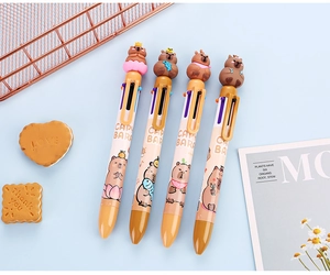 Detailed view of four Capybara cartoon multi-color retractable pens on a blue desk