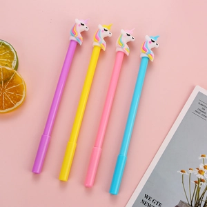 Set of four colorful unicorn pens in purple, yellow, pink, and light blue on pink background