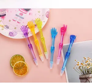 Set of 6 colorful creative skeleton hand gesture ballpoint pens on a pink background