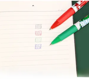 Close-up of 4-color Christmas ballpoint pens with festive illustrations on a notebook