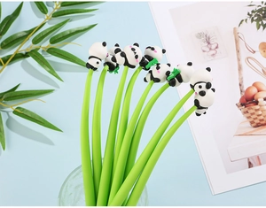 Primer plano de bolígrafos panda 3D en un vaso con hojas verdes y revista de fondo