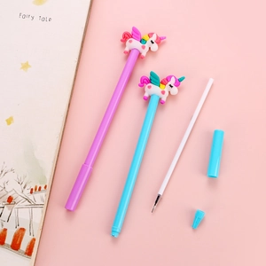 Stylos gel licorne mignons en violet et bleu avec figurines 3D sur un carnet rose