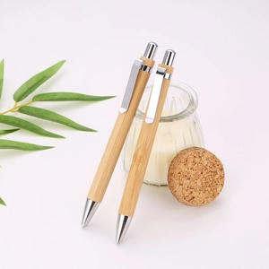 Detail of two natural bamboo ballpoint pens with silver metal clips on white background