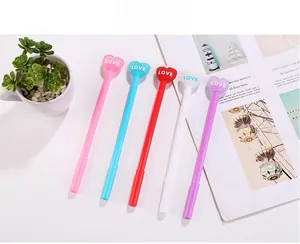 Set of colorful creative heart top gel pens with LOVE engraving on a bright desk setting
