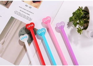 Detail of colorful cartoon pens with 3D heart-shaped LOVE caps on a desk