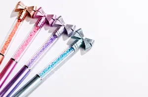 Dettaglio di quattro penne glitterate con cristalli colorati e fiocchi metallici