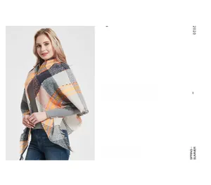 Detail of plaid scarf featuring orange and grey checkered pattern with soft fringe edges