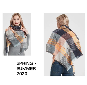 Detail of plaid scarf with orange and navy tones, fringed edges and soft knit texture