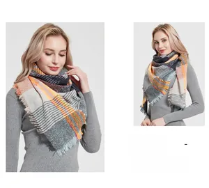 Close-up of thick plaid tassel shawl with orange, grey and beige geometric patterns