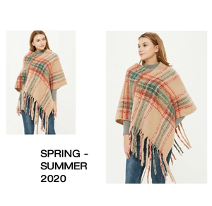 Close-up of camel plaid knit poncho with fringe details and thick mohair texture