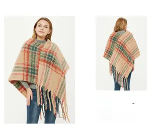 Detail of bohemian plaid knit poncho with long tassels and soft mohair-like texture