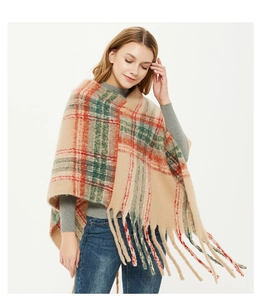 Detail of warm khaki plaid poncho with soft fringes and classic red green check pattern