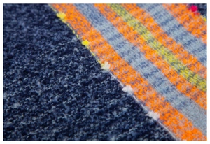 Macro shot of navy blue boucle yarn texture and colorful plaid knit fabric patterns