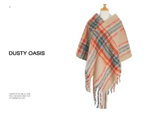 Close-up of beige plaid poncho with mohair texture and fringe tassel detailing