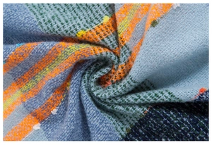 Detail of soft rainbow plaid scarf featuring textured bouclé yarn and colorful fringes
