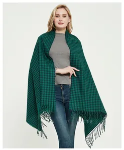 Detail of green and black checkered scarf with tassel trim on a model in winter style