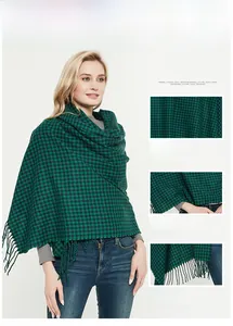 Detail of green and black plaid cashmere-like scarf with soft texture and fringe tassels
